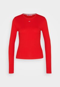 T-shirt rosso a maniche lunghe in tessuto a costine. Presenta un collo rotondo e un piccolo logo sul petto. Design semplice e aderente.