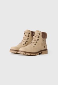 Bottes beige à la cheville avec un extérieur en suède, un col en fausse fourrure, des œillets en métal et une semelle en caoutchouc texturée. Comprend des accents et des coutures marron.