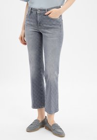 Grijze denim jeans met een vervaagde was, voorzien van een subtiel patroon op de onderste benen, rechte snit, vijf zakken en een sluiting met knoop aan de voorkant.