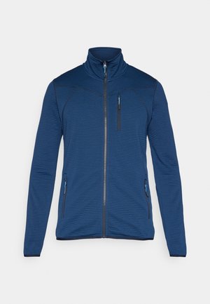 Laivastonsininen vetoketjullinen takki, jossa on resoripintainen pinta, korkea kaulus ja kontrastiväriset siniset vetoketjut. Takissa on kaksi sivutaskua ja yksi rintatasku.