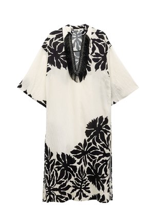 Vestido de estampado floral en blanco y negro, tejido ligero, corte holgado, escote en V con detalles de flecos negros y mangas cortas.