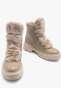 Beżowe botki za kostkę z miękkim kołnierzem z sztucznego futra, sznurowanym przodem, wyściełanym językiem i grubą gumową podeszwą z teksturowanym bieżnikiem.