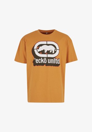 Rövid ujjú, narancssárga pamut póló, fekete és fehér grafikával, amelyen egy rinocérosz mintázat látható, alatta szöveggel.