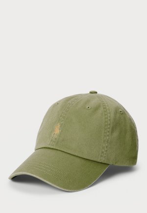 Grønn bomull baseballcap med buet skjerm. Har brodert logo i lys gul, ventilasjonshull og justerbar stropp bak.