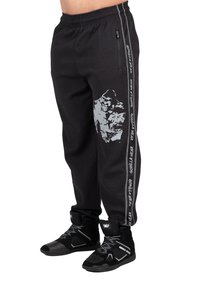 Zwarte sportieve zwempants van textuurstof, met een grijze grafiek en branding langs de zijkant, gecombineerd met zwarte hoge sneakers.