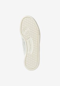 Semelle d'une basket blanche Reebok montrant un motif de crampons en diamant, une prise circulaire et le nom de la marque embossé sur la semelle extérieure en caoutchouc.