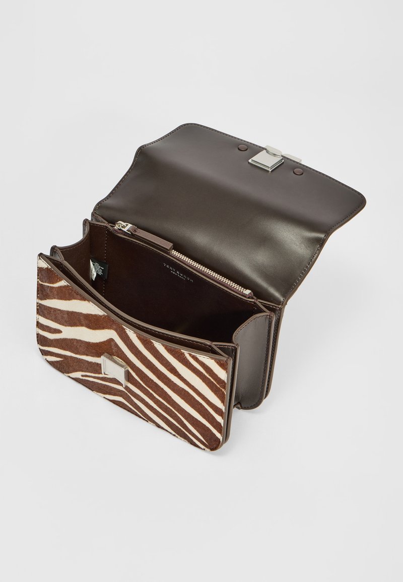 Brązowa skórzana torba z klapą w wzór zebry, srebrnymi akcentami i zamykanym na zamek przedziałem, z gładkim wnętrzem i usztywnionym kształtem.