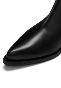 Schwarze, spitze Ankle Boots aus Leder mit glatter Oberfläche und schlanker Silhouette. Verfügt über eine flache, leicht strukturierte Sohle.