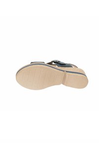 Sandal nera con cinturino testurizzato e dettaglio della fibbia, dotata di suola in gomma marrone chiaro con scanalature per aderenza e flessibilità.