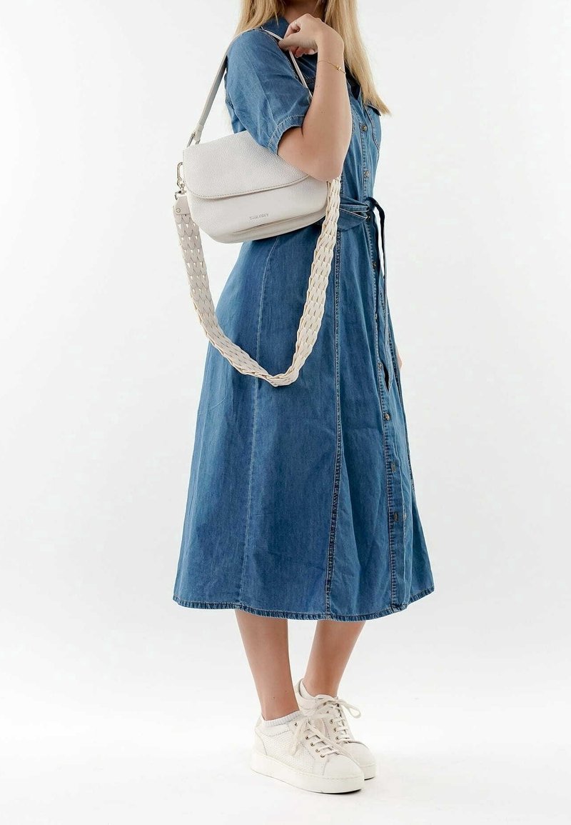 Denim skjorte kjole med korte ærmer, indsnævret talje og en svajende nederdel. Hvid crossbody taske med en flettet rem. Hvide sneakers.