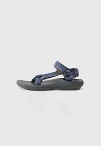 Marineblå sportsandal med justerbare stropper, gummisåle, teksturert fotbed og en lavprofildesign for utendørs holdbarhet.