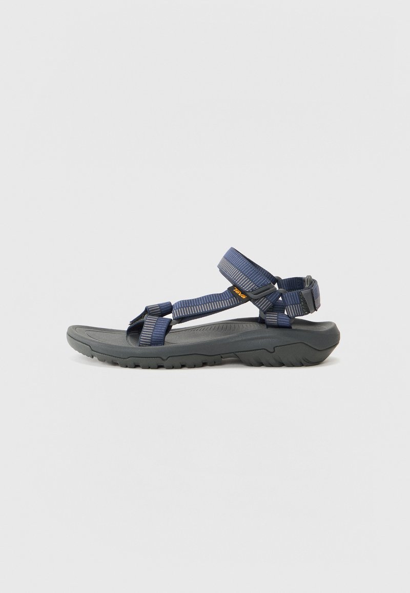 Marineblå sportsandal med justerbare stropper, gummisåle, teksturert fotbed og en lavprofildesign for utendørs holdbarhet.