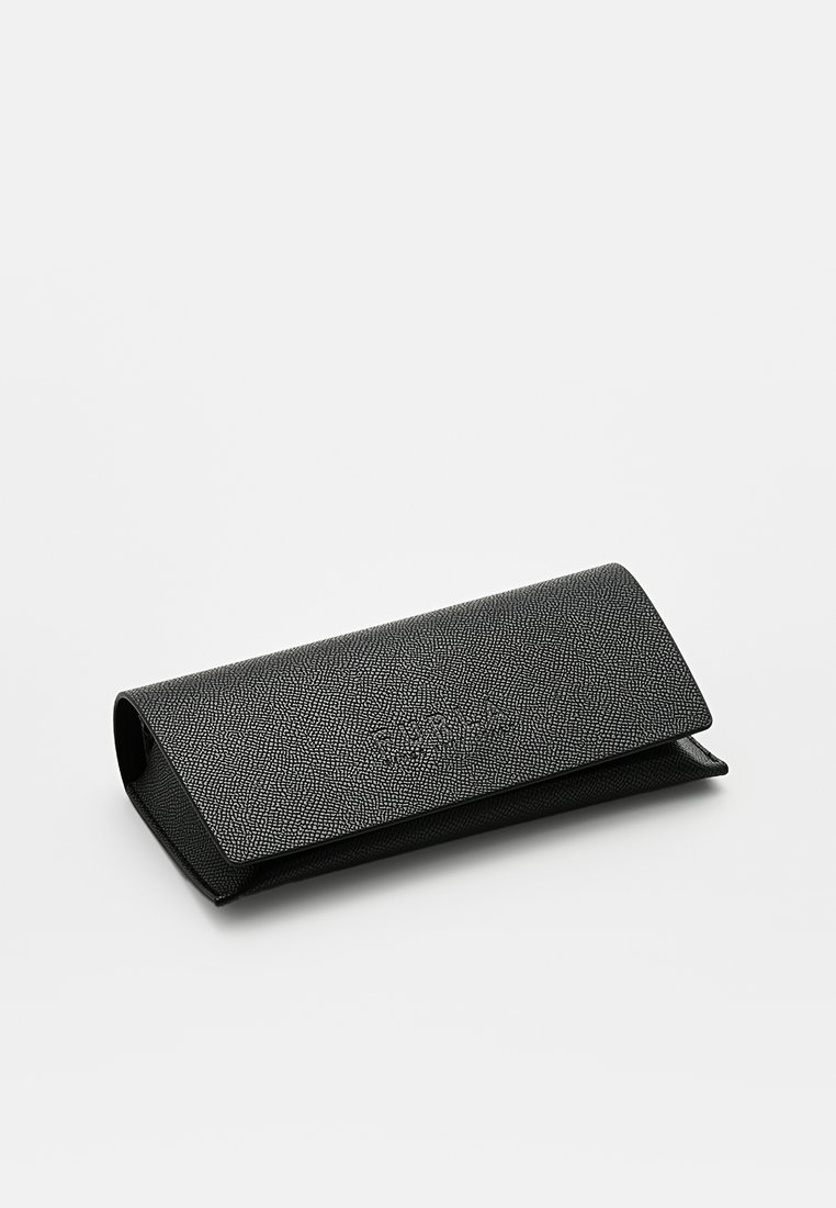 Étui en cuir noir texturé pour lunettes avec une fermeture à rabat. Forme rectangulaire avec une surface lisse et un motif en relief subtil.