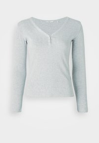 Heledashall hallise värviga pikkade varrukatega pluus, mis on valmistatud ribakangast. Omab V-kaelust ja kolme nuppu kaelusel, slim fit disainiga.