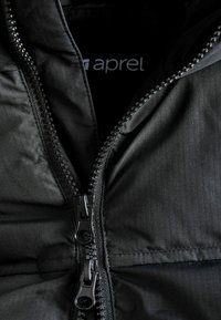 Detalle de una chaqueta de plumas negra con cierre de doble cremallera, que presenta una tela suave, ligeramente texturizada y un brillo sutil.