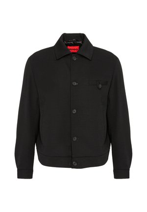Schwarze Blousonjacke mit Kragen, langen Ärmeln und einer kleinen Knopftasche auf der linken Brust. Rotes „HUGO“-Etikett im Kragen.