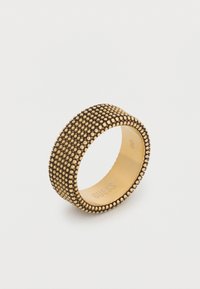 Δαχτυλίδι σε χρυσή απόχρωση με υφή και μικρές στρογγυλές προεξοχές. Λεία εσωτερική επιφάνεια με χαρακτική "GUESS" και μέγεθος 60.