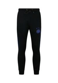 Zwarte joggers gemaakt van zachte stof, met een trekkoord in de taille, zij blauwe strepen en een logo met sterren op de linkerdij.