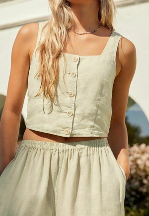 Top court vert clair à encolure carrée, avec fermeture à boutons sur le devant, associé à une jupe à taille élastique.