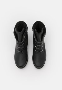 Bottes noires avec un extérieur en cuir lisse, une doublure texturée, des accents métalliques et une fermeture éclair. Présentent un design à lacets et un bout arrondi.