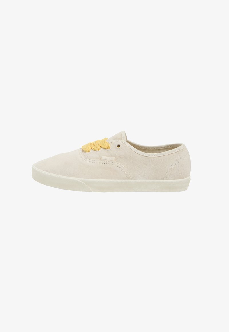Beige suede sneakers with a low-top design, featuring yellow laces, round toe, and a flat rubber sole. Clean, minimalist style.