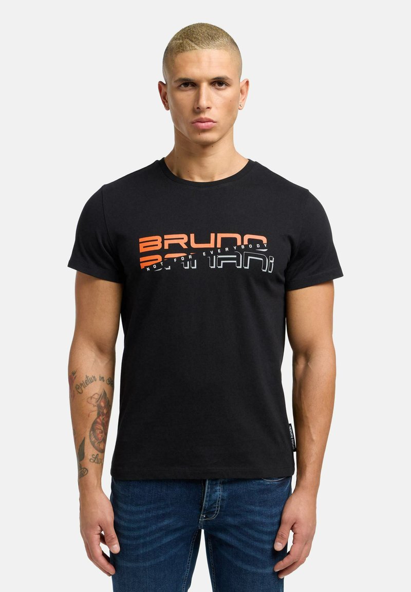 Sort bomulds t-shirt med iøjnefaldende grafisk tekst i orange og hvid. Korte ærmer, rund hals og et mærke i kanten. Denim jeans synlige.