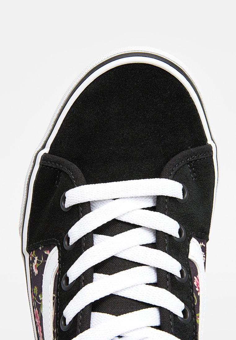 Baskets en suède noir avec des détails en tissu floral, lacets blancs et bande latérale. Bout rond et col rembourré pour le confort.