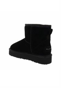 Botas de tobillo de ante negro con suela de goma plana, punta redondeada y un collar suave y acolchado. Presenta una etiqueta de la marca en el talón.
