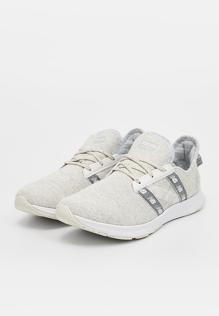 Chaussures de sport gris clair avec une tige texturée, un design à lacets, un col rembourré et une semelle blanche avec des bandes d'accent gris.
