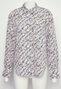 Chemise à boutons florale en tissu léger. Elle présente des fleurs multicolores sur un fond noir, avec un col et des manches longues.