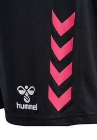 Svarta sportshorts med rosa chevronränder på sidan och en vit logga från Hummel i nedre vänstra hörnet.