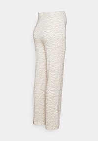 Crèmekleurige broek met een zebra-patroon, met een relaxte pasvorm, wijde benen en een gladde, zachte stofstructuur.