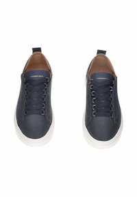 Sneakers in pelle blu navy con suole bianche e lacci neri, contrassegnati con "Alexander Smith" sulla linguetta, visti dall'alto.