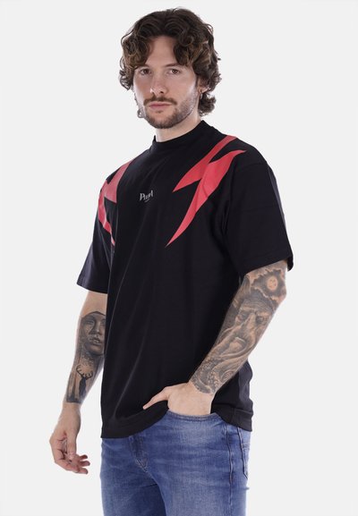 T-shirt nera a maniche corte con design di fulmini rossi sulle spalle e un piccolo logo sul petto. Tessuto morbido e vestibilità rilassata.