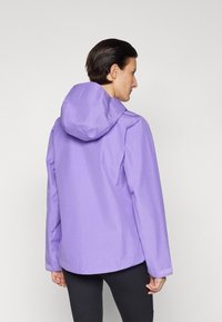 Fioletowa, lekka kurtka z kapturem, charakteryzująca się gładką teksturą i prostym designem. Rękawy mają regulowane mankiety na rzep.