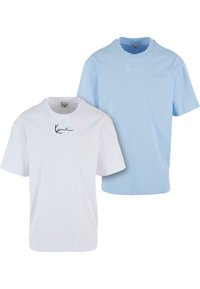 Deux t-shirts à manches courtes : un blanc et un bleu clair, chacun avec un col rond et un logo noir en signature sur le devant.