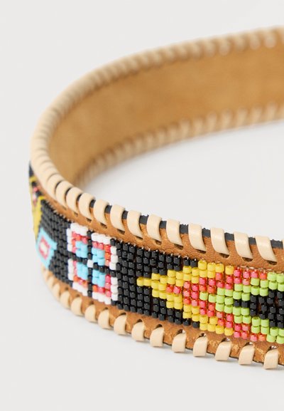 Bracelet en cuir marron avec des perles multicolores formant des motifs géométriques et floraux cousus le long des bords.