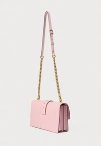 Ροζ δερμάτινη τσάντα χειρός με δομημένο σχήμα, διαθέτοντας χρυσή αλυσίδα λουρί, χρυσές λεπτομέρειες και κλείσιμο με καπάκι και καρφιά.