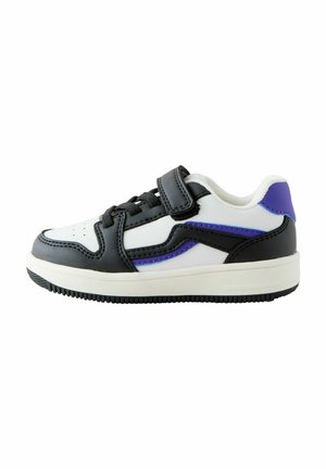 Hvid sneakers med sorte accenter, lilla detaljer og en tekstureret gummisål. Har en Velcro-strop og snørebåndslukning for justerbar pasform.