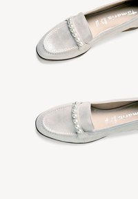 Grey suede loafers feature a smooth finish with a row of decorative pearls on the strap, rounded toe, and low profile sole.
