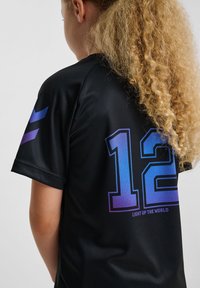Zwart sportshirt met het nummer 12 in een verloop van blauw naar paars op de achterkant, met de tekst "LIGHT UP THE WORLD" eronder.