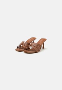 Brune faux skinnheler med flere horisontale stropper, åpen tå-design og en slank stiletthæl. Glatt tekstur, minimalistisk stil.