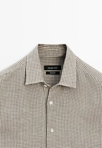 Brązowo-biała koszula w kratę z długim rękawem, kołnierzem i guzikami z przodu, z metką Massimo Dutti wewnątrz kołnierza.