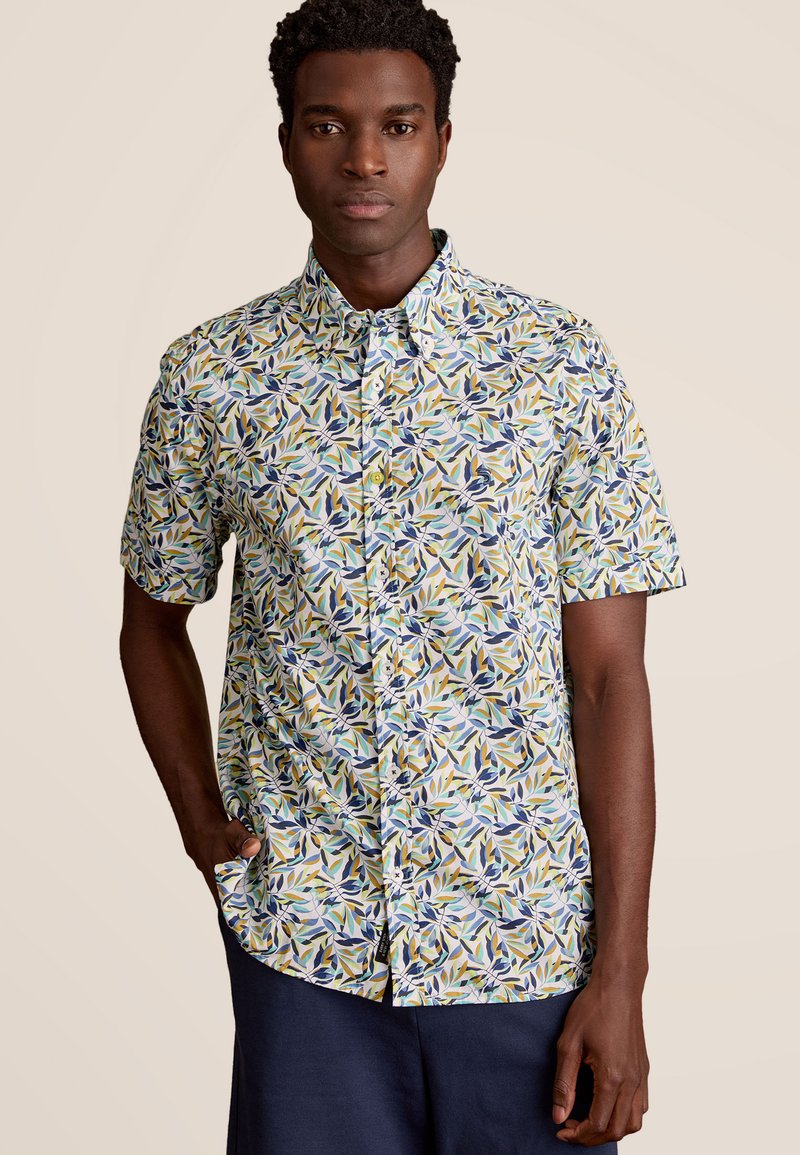 Korte mouwen shirt van lichte stof met een meerkleurig bladerenpatroon in tinten groen, blauw en geel; met knoopsluiting op de kraag.