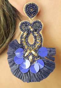 Orecchini in perline con base dorata, caratterizzati da perline blu scuro, paillettes blu circolari e un dettaglio in tessuto frangiato e texture.