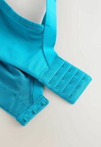 Sutien sport de culoare turquoise, cu bretele ajustabile, un panou texturat și mai multe închizători cu cârlig pentru o potrivire sigură.