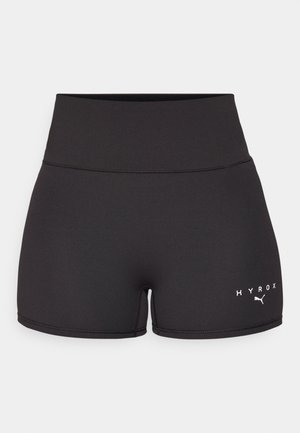 Shorts de sport noirs en tissu extensible. Design taille haute avec le texte et le logo blanc "HYROX" en bas à gauche. Texture lisse.