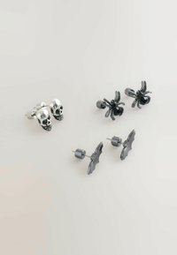 Set od četiri naušnice: dvije srebrne lubanje, jedan crni pauk s rhinestones, i dva crna šišmiša, svi s metalnim postovima.