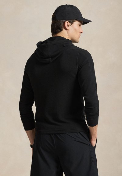 Μαύρο μακρυμάνικο hoodie με υφή, που διαθέτει κουκούλα και ριμπ μανσέτες, συνδυασμένο με μαύρο αθλητικό σορτς.