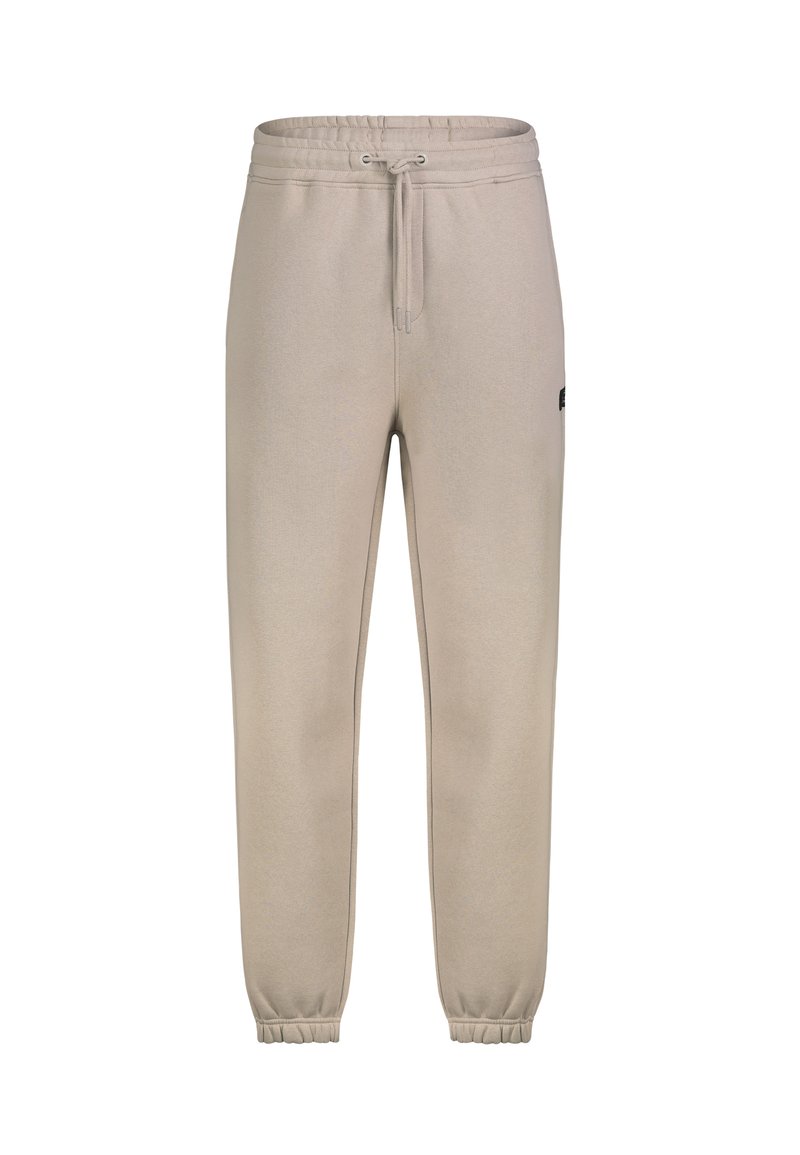 Beige Jogginghose mit elastischem Bund und Bündchen, Kordelzugverschluss und einem kleinen Logo-Patch an der Seite.